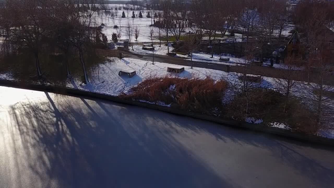 volando hacia arriba sobre un lago congelado perfecto mirando hacia el parque nevado de mogosoaia, bucarest, rumania
