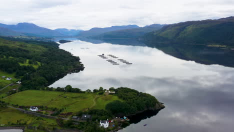 wide drone shot of mountains and water in loch carron, in the scottish highlands