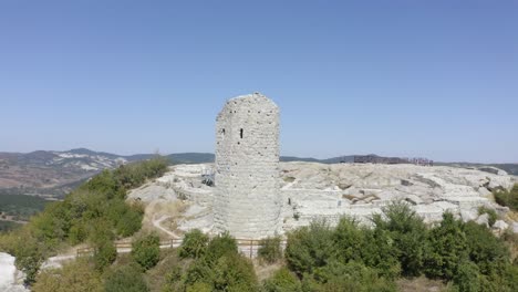 drone orbiting around the palace complex of the ancient historical landmark of perperikon, showing a high tower with a viewdeck, located in the province of kardzhali in bulgaria