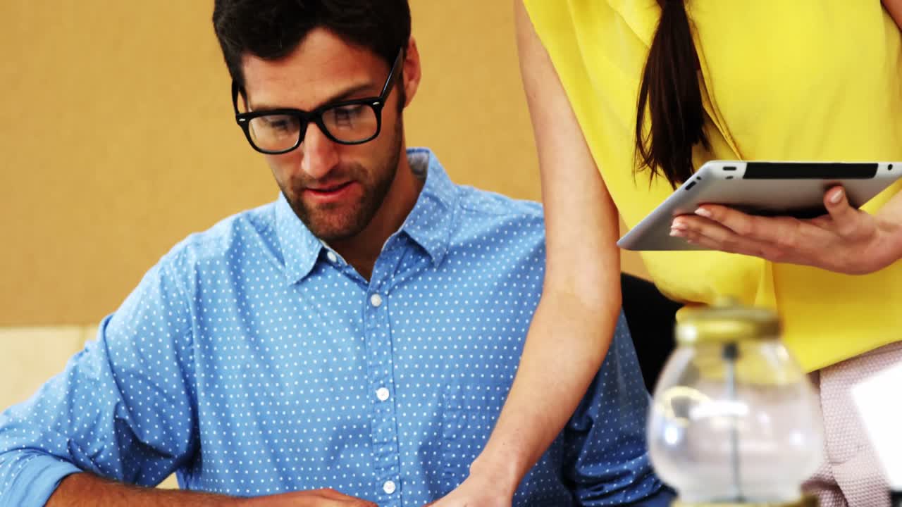 ejecutivo de negocios y compañero de trabajo interactuando mientras usan una tableta digital