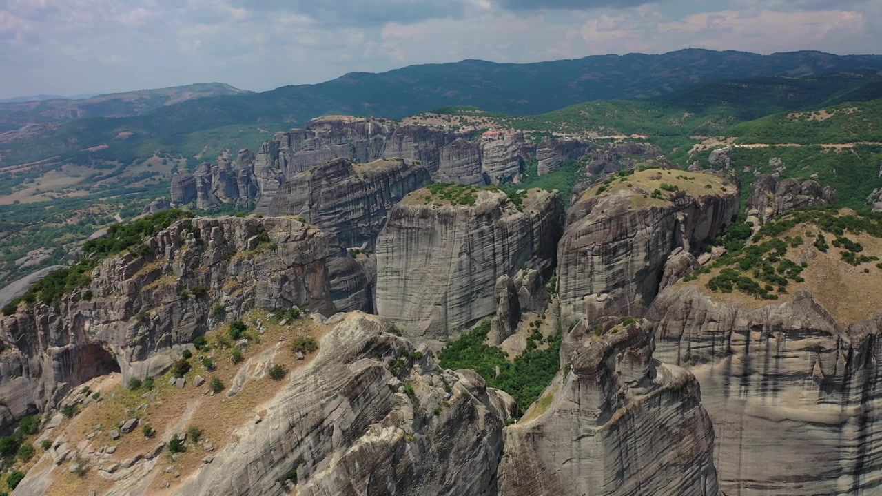 Splendido panorama ripreso da drone dei pilastri rocciosi di Meteora e degli antichi monasteri arroccati sulle scogliere. Il filmato mostra la vasta foresta di pietra, valli lussureggianti e verdi e la città di Kalabaka annidata in basso.