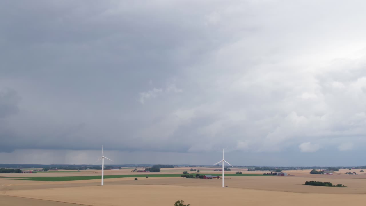 스웨덴 남부의 풍력 터빈이 있는 광활한 들판을 드러내는 항공 샷 기울기