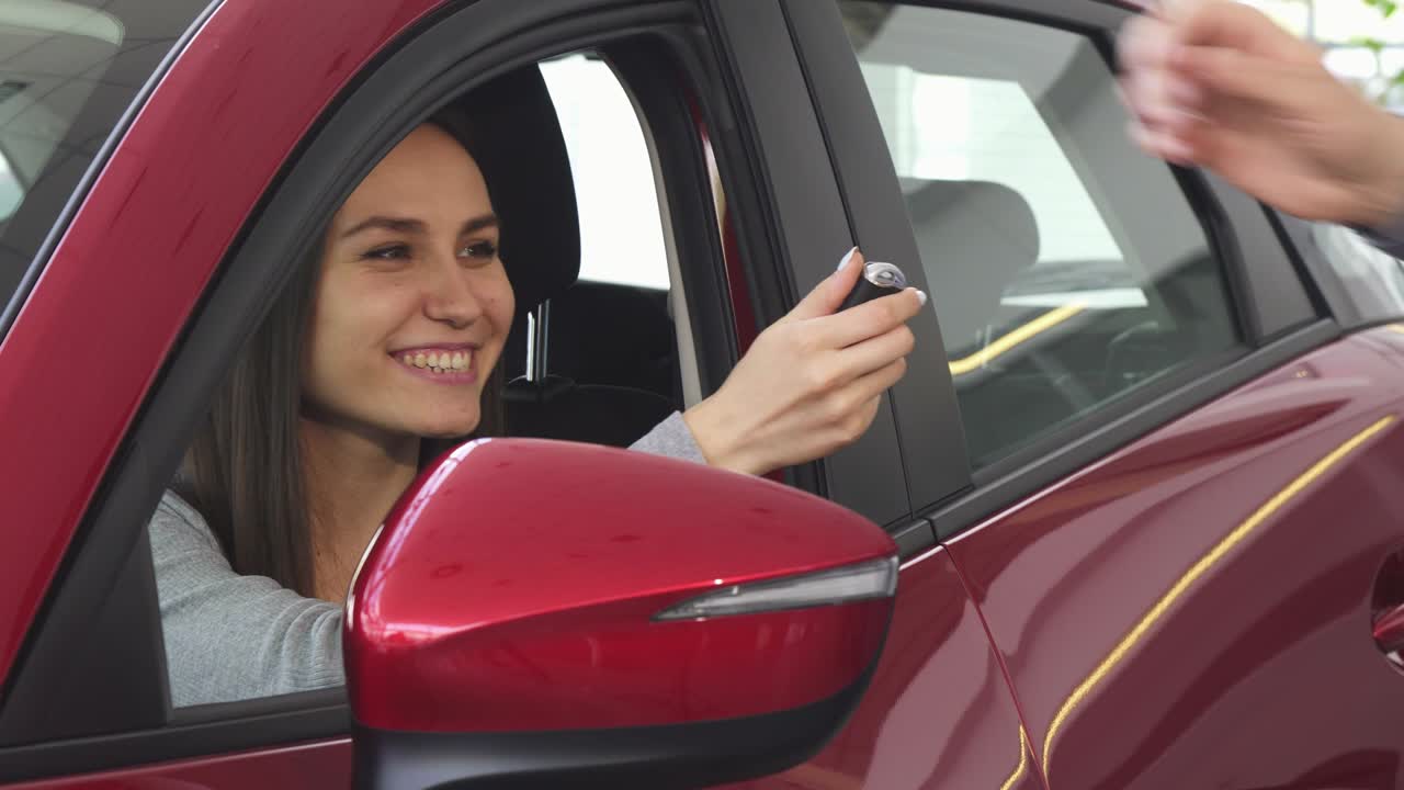 joven feliz recibiendo las llaves del coche de su nuevo automóvil