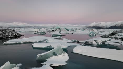 Volando-Sobre-La-Laguna-Glaciar-De-Jökulsárlón-Durante-La-Puesta-De-Sol-Rosa-En-El-Sur-De-Islandia---Disparo-De-Drones