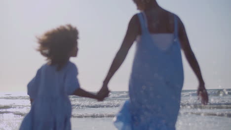 loving mother and her cute daughter walking hand in hand at seashore