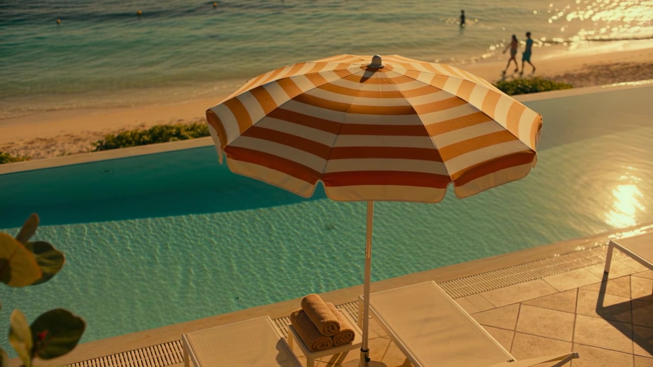 Opening shot showing striped orange umbrella on pool deck, companions walking shoreline in swimwear