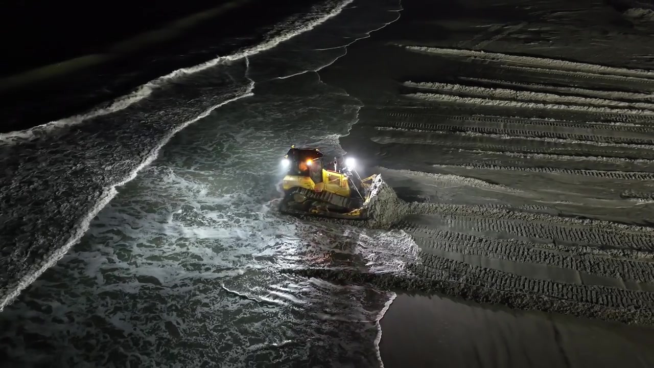 Ripascimento notturno della spiaggia con bulldozer a Ocean City NJ