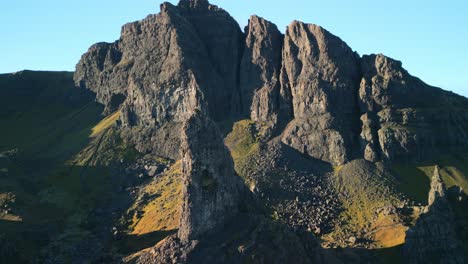 crumbling cliffs of mountain with ancient volcanic stone spire the old man of storr in foreground