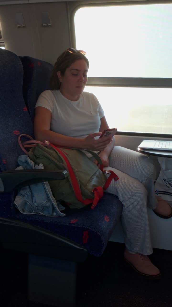 Young Woman Relaxing with Her Phone on a Train Journey