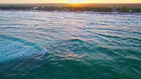 Drones-Volando-Sobre-Las-Vibrantes-Olas-De-Agua-Azul-Turquesa-Del-Océano-Cerca-De-La-Playa-Caribeña-En-México-Durante-La-Puesta-De-Sol