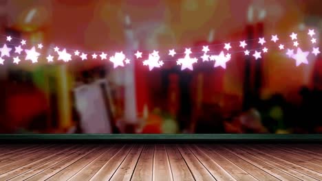 Glowing-pink-star-shaped-fairy-light-decoration-hanging-over-wooden-plank