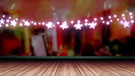 glowing pink star shaped fairy light decoration hanging over wooden plank