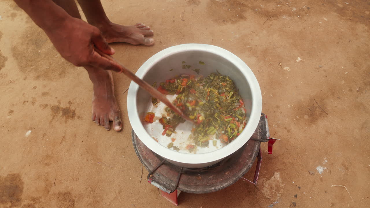 agitar un estofado tradicional en una olla grande al aire libre