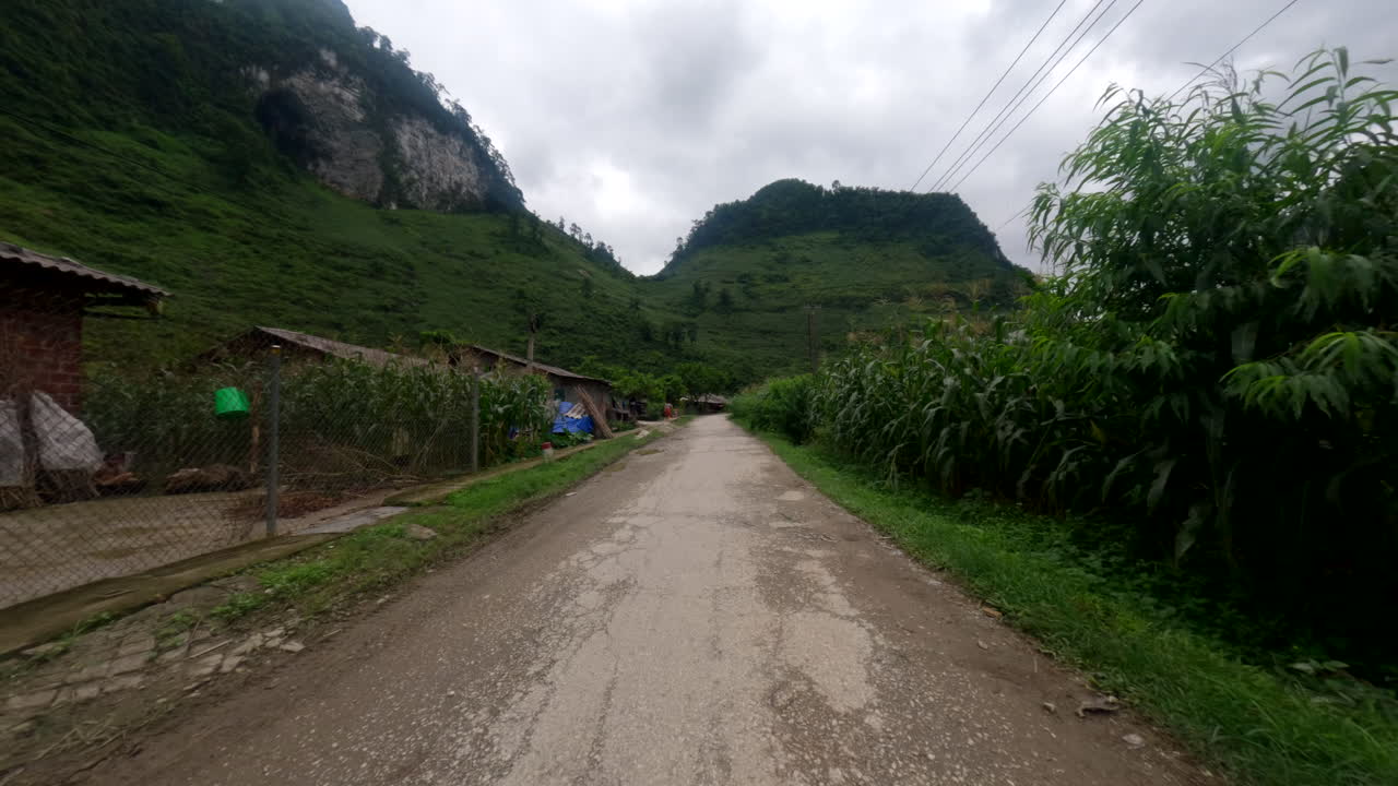 Remote Road Through Cornfields And Mountains In Ha Giang Loop, Vietnam. POV Shot