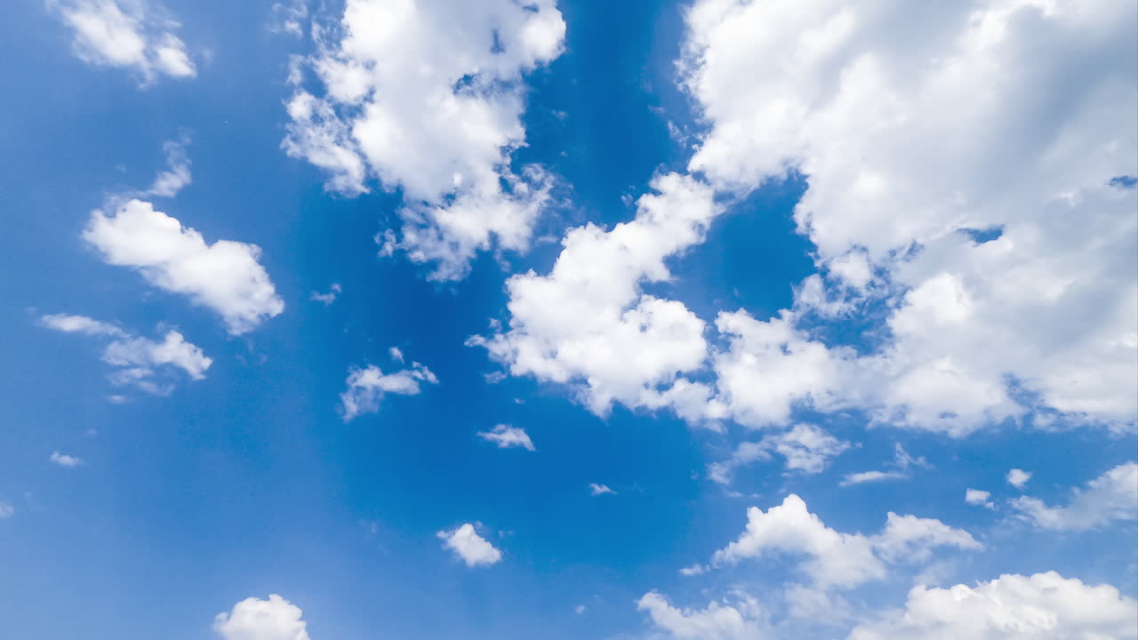 Amazing light cotton clouds fly away and disappearing in the sky. Blue horizon cleaning from clouds timelapse. Low angle view.