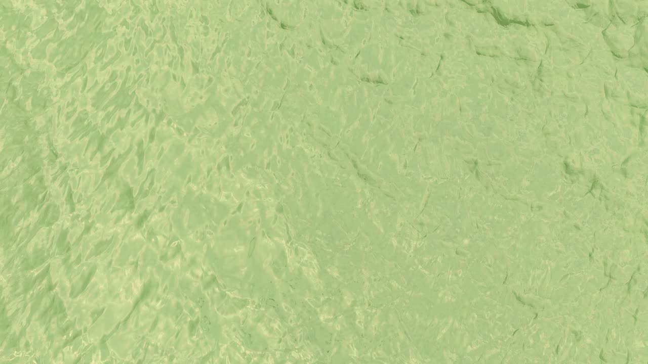 Drone captures minimal, textured green ocean surface with gentle ripples and natural light reflections