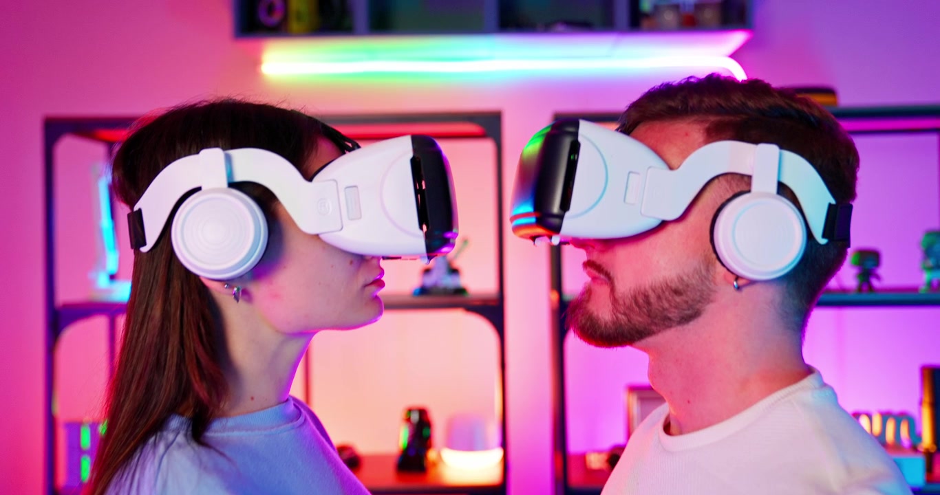 Giovane coppia che indossa visori VR e cuffie in una stanza illuminata al neon