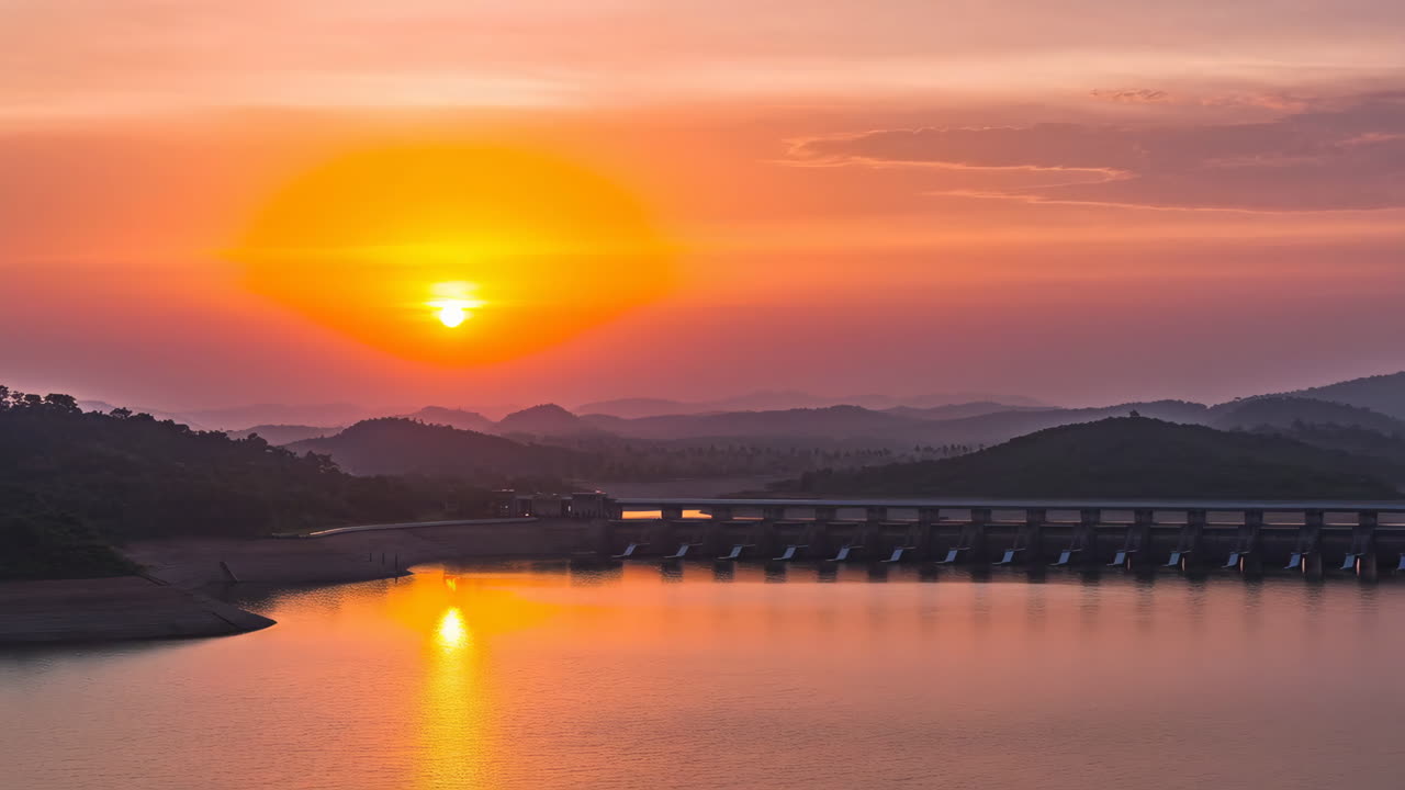 Sunset over a Dam and Reservoir with Hills
