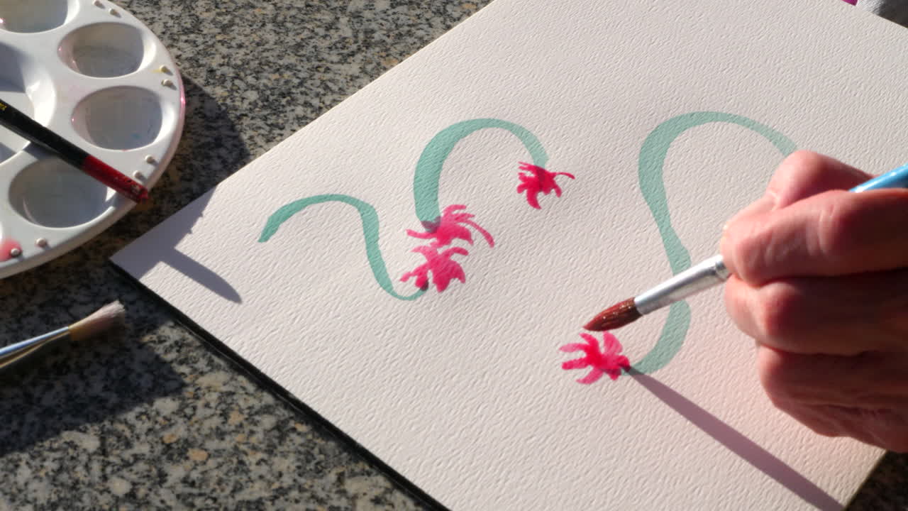 긴장을 풀고 스트레스를 풀기 위해 수채화로 다채로운 꽃 예술 작품을 그리는 노인 여성 예술가