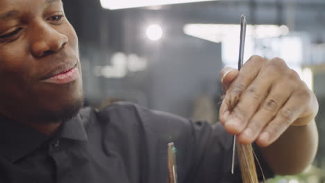 cheerful black barber giving haircut to client