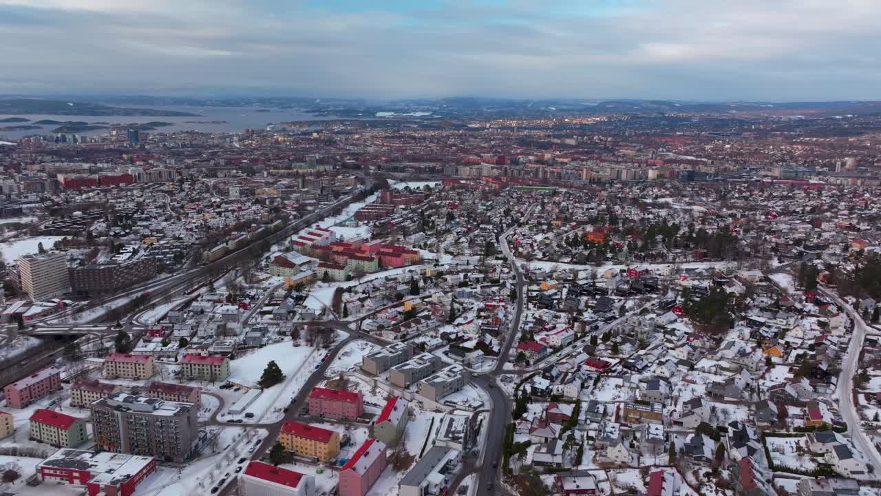 Oslo Fjord downtown cityscape Norge Norway aerial drone Gamle Tonsengagen Bjerke Arvoll morning buildings cars traffic highway roads snowing cold cloudy winter day gray skies forward pan up