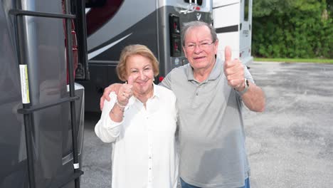 super happy customers on the rv lot smile and give an approving thumbs-up sign with their hands