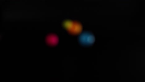 múltiples bolas de colores rebotando en el fondo oscuro