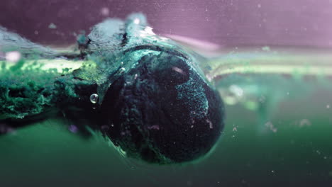 A pill dissolving in liquid with bubbles rising and dispersing in the fluid