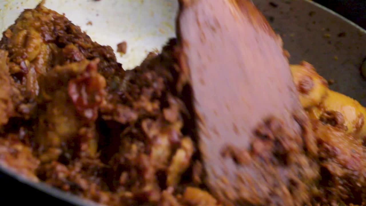 receta casera de pollo picante al estilo indio cocinada en una sartén por el chef, revolviendo el curry de pollo y cocinando la receta de pollo, cocinando comida no vegetariana