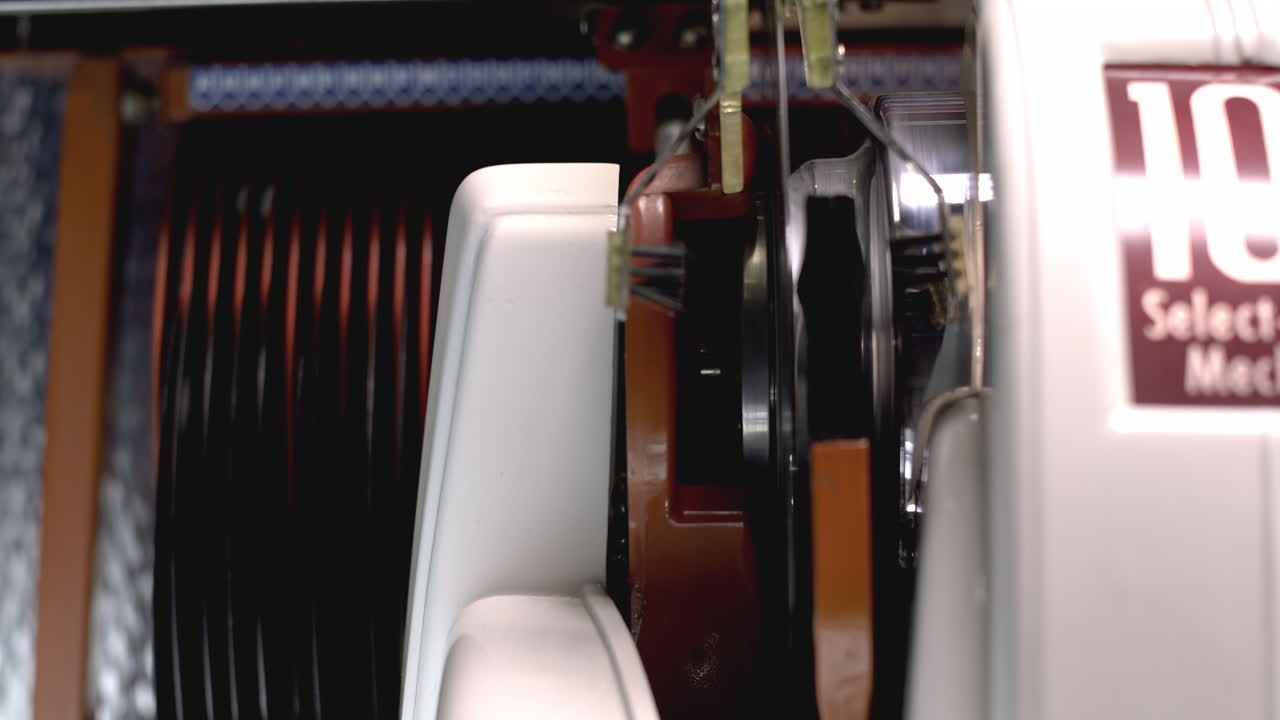 Il cambia dischi del jukebox carica un vinile e inizia a suonare, primo piano di un disco che gira, stile vintage retrò