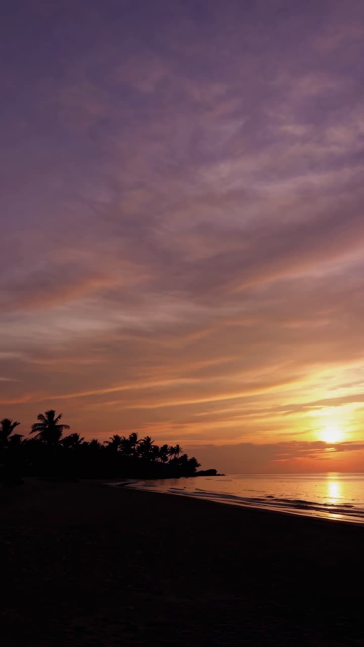 A serene sunset video captures a vibrant sky over a tranquil beach