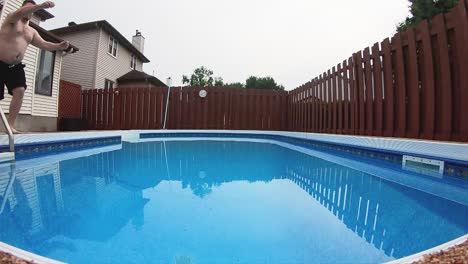 hombre gordo salta a la piscina del patio trasero con un gran chapuzón en cámara lenta