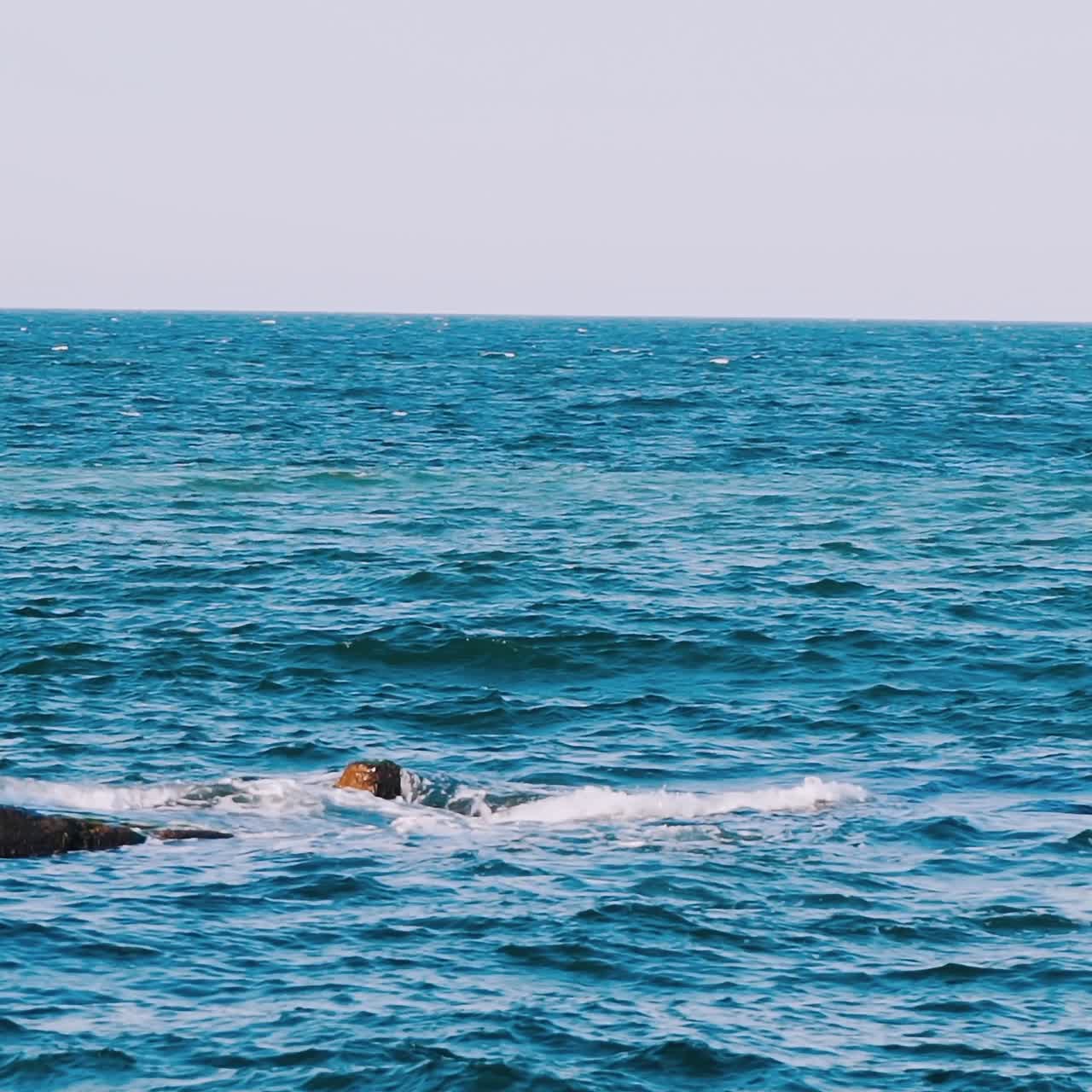 Amazing view of blue sea water. Waves moving and breaking on pier. Beautiful atmosphere of nature seascape in daytime.