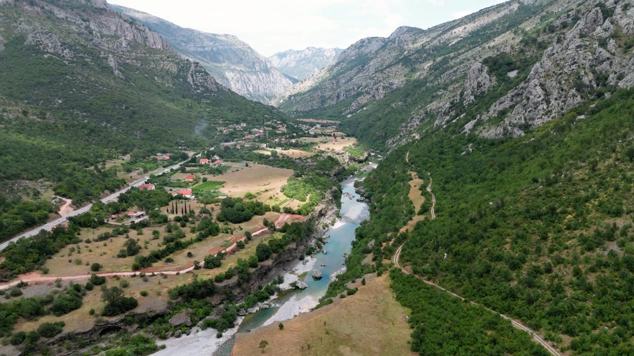 Karadağ'ın geniş manzarasını gözler önüne seriyor: Podgorica yakınlarındaki Lutovo dağları ve Moraça Nehri üzerinde havadan çekimle nehir yeşillikleri, dağları ve vadisi.