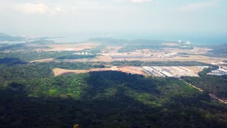 aerial panorama, clouds shadows on tropical jungle, pacific side of panama canal and panama city in misty background, drone shot