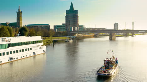 zoom out of a sailorboat on a river next to a ship and a bridge