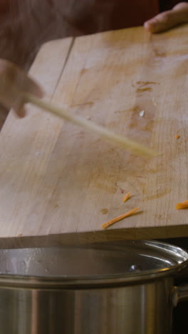 adding chopped carrots to a steaming pot