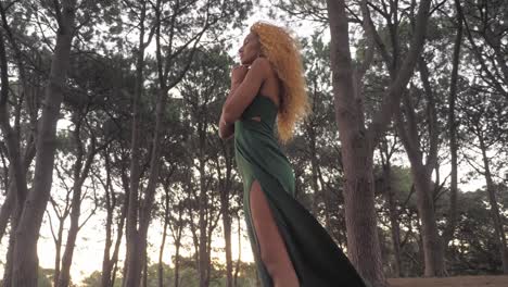 a beautiful woman standing in the forest alone and appreciating the beauty of mother nature - low angle shot