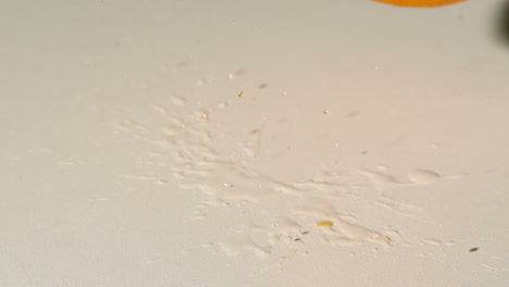 orange falling and bouncing on white surface