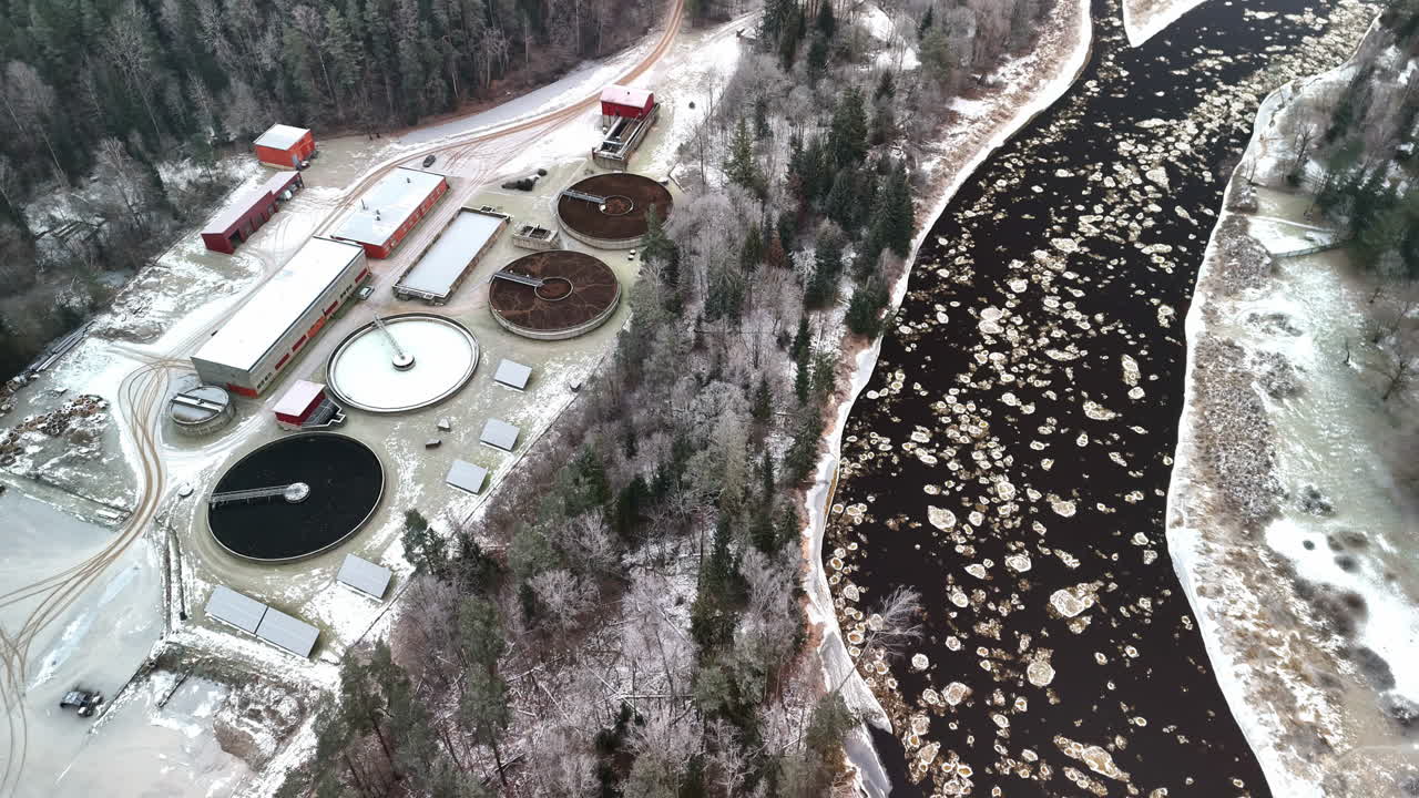 Industrial water treatment plant next to a frozen river. Aerial view