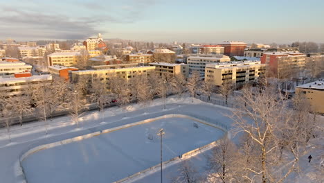 aerial view of a snowy city with an outdoor ice rink