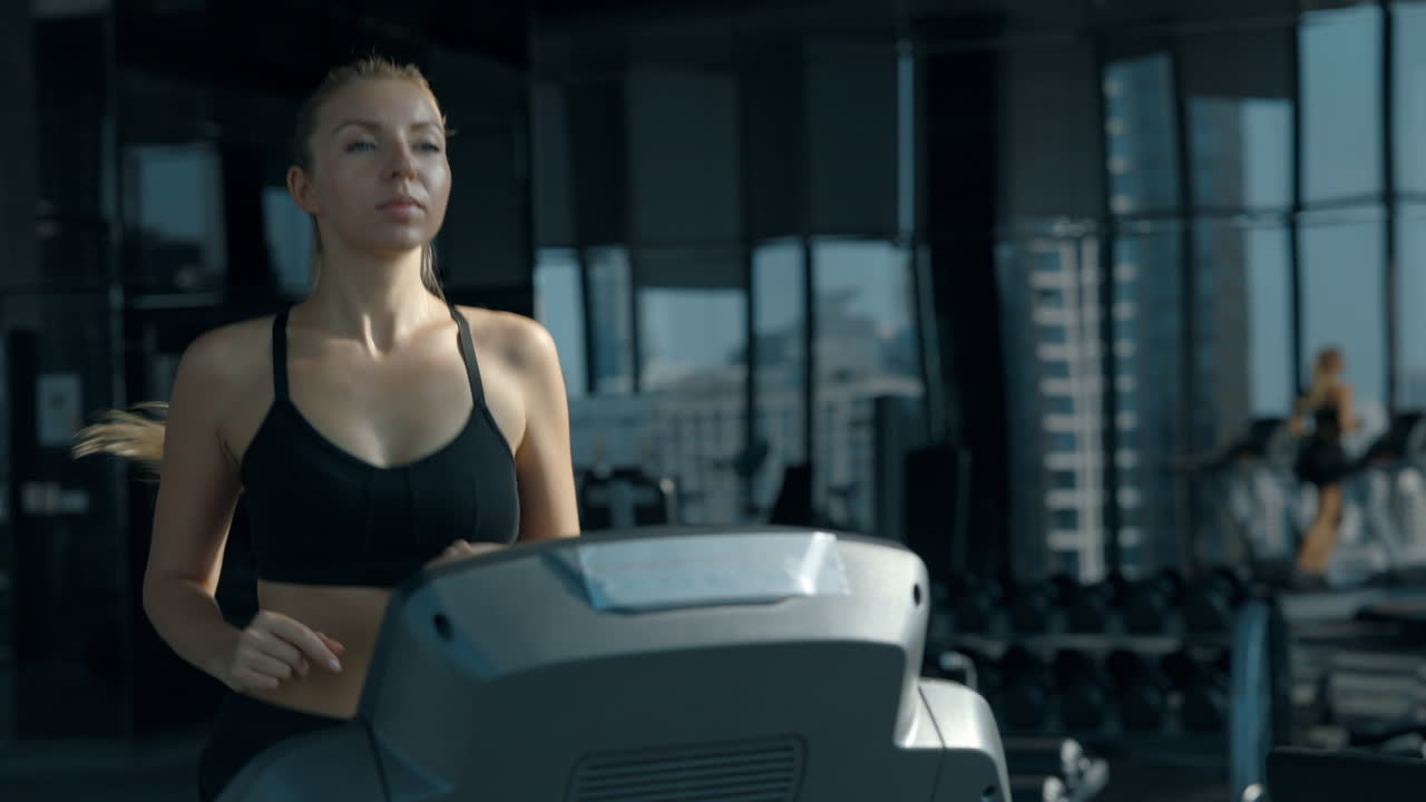 Woman running on a treadmill in a modern gym