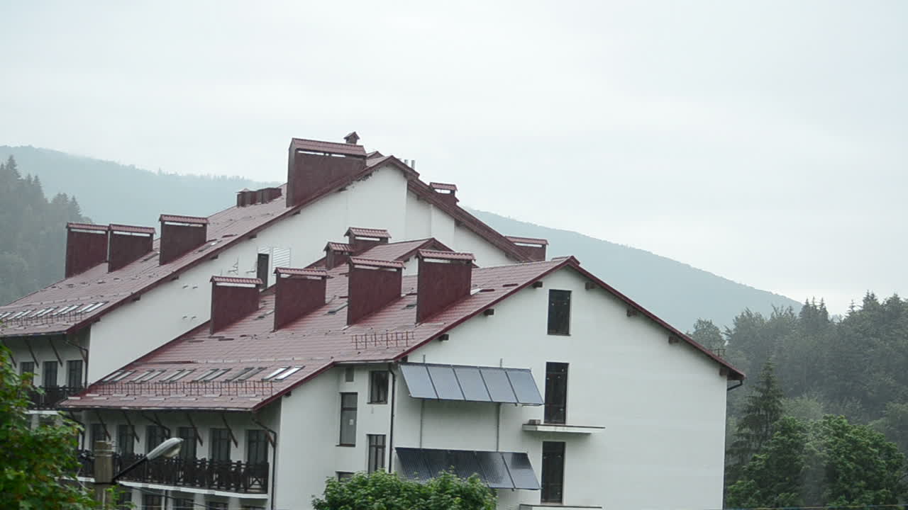 Rain on a roof of hotel. Hotel in mountains
