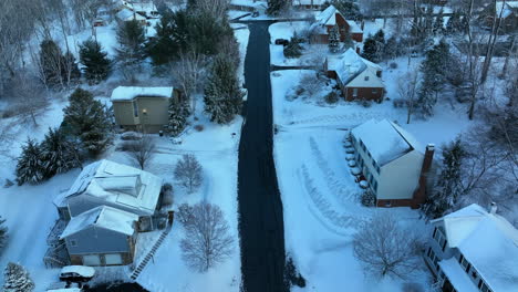 descending aerial on homes and lawn yards covered in fresh winter snow