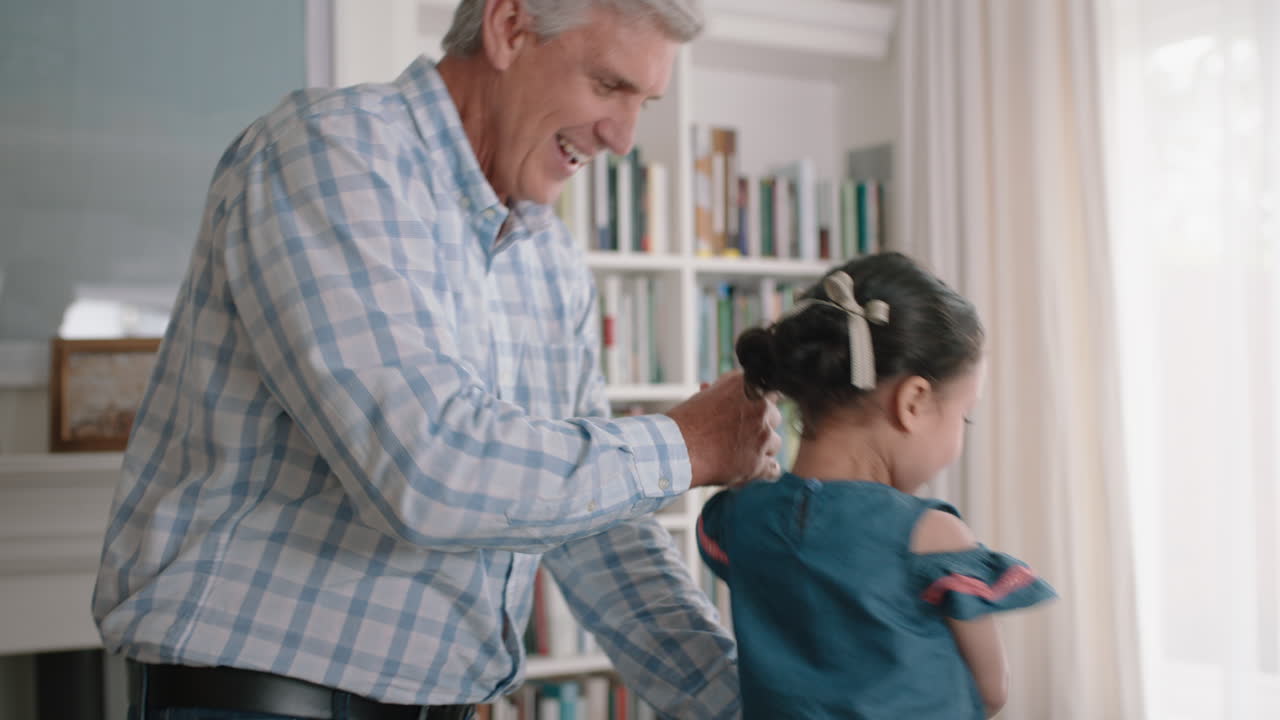 abuelo feliz bailando con la niña en casa abuelo divirtiéndose bailando con la nieta celebrando el fin de semana en familia juntos 4k