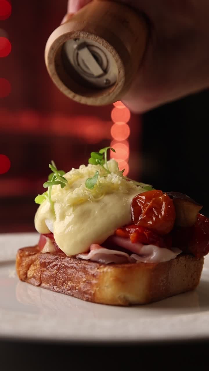 Chef Grinding Pepper onto a Gourmet Breakfast Toast with Poached Egg