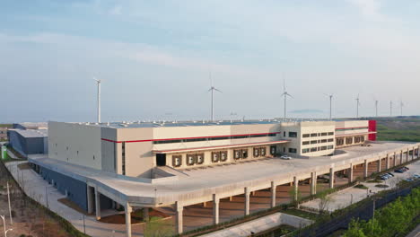 aerial shot of newly built distribution warehouse with windmills in the background