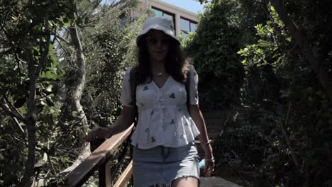 mujer caucásica caminando por un sendero de madera