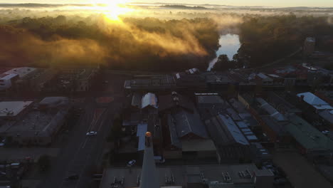 Luftaufnahme-Eines-Wunderschönen-Sonnenaufgangs-An-Einem-Kalten-Wintermorgen-Mit-Einer-Nebelschicht,-Die-Die-Landschaft-Im-Hintergrund-In-Der-Ländlichen-Stadt-Wagga-Wagga,-NSW,-Australien,-Bedeckt