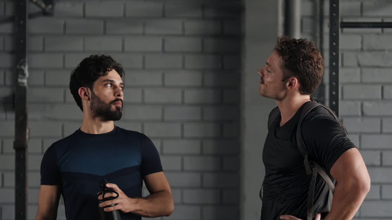 체육관 에서 운동 을 한 후 이야기 하는 남자 들